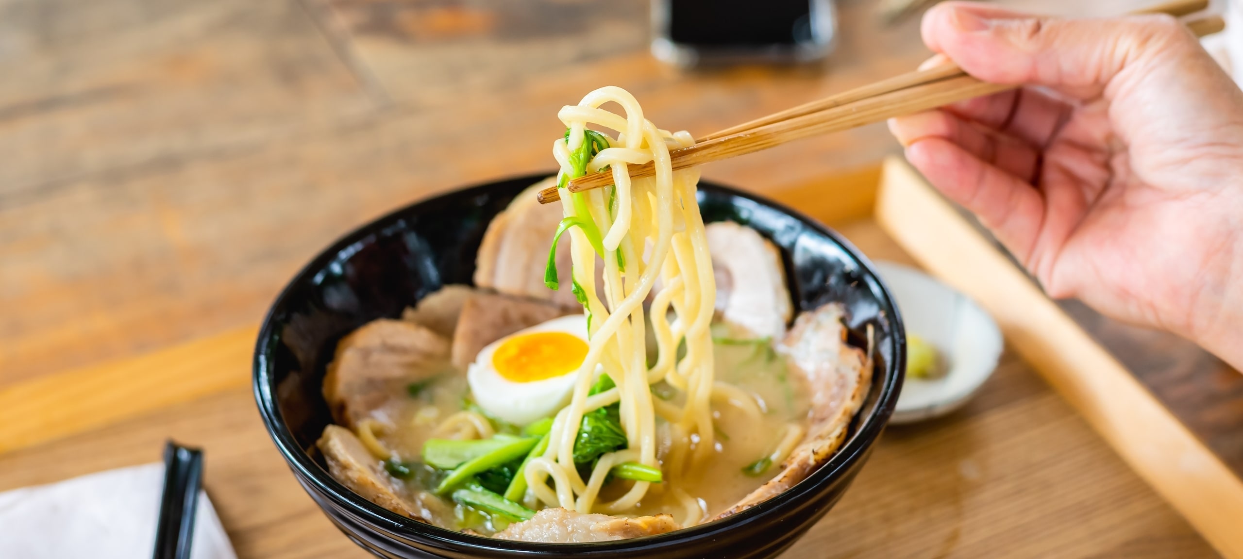 Close up image of ramen and chopsticks on restaurant table